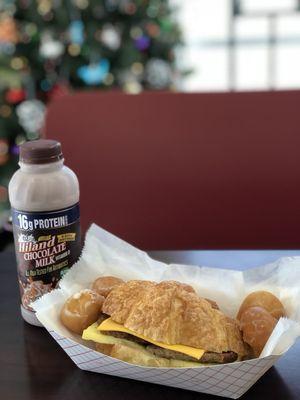 Sausage egg and cheese croissant, with half a dozen glazed donut holes, and a chocolate milk!