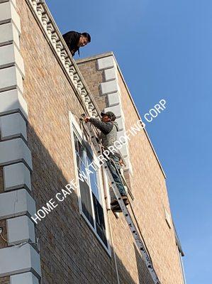 Fixing up the cracks around the top window with waterproof cement