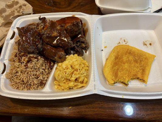 Jerk Chicken with mac and cheese, rice, and a Jamaican beef patty