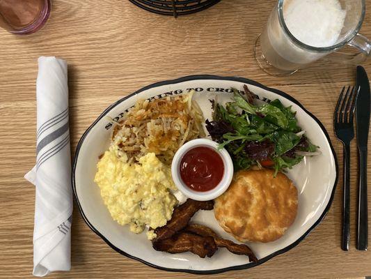 Classic breakfast with eggs, hash, crispy bacon and a biscuit.