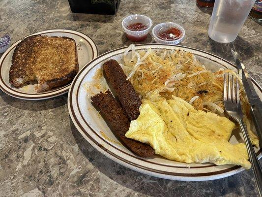 Scrambled eggs with hashbrowns, chipotle veggie sausage, and wheat toast.