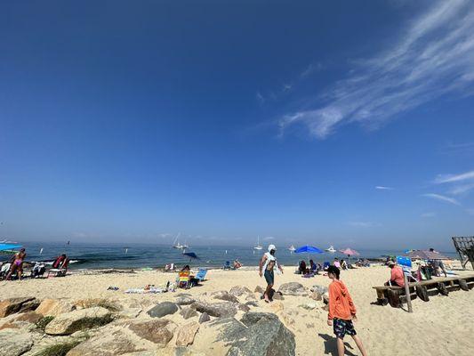 Beach goers relaxing on tiny Menemsha beach next to gas station