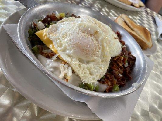 Breakfast skillet with potatoes, sausage and sunny side up eggs