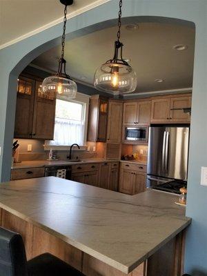 Kitchen remodel with farmhouse pendant lighting and natural quartzite countertops