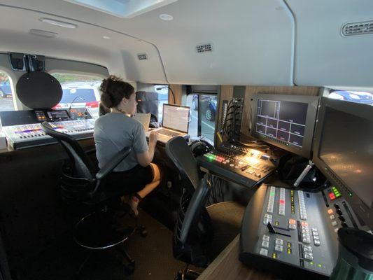 A view of the audio desk (left) and the video desk (right) in the RadHaus van, with one of our audio engineers setting up for a show.