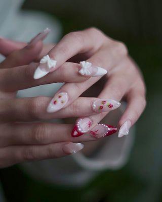 advanced nail art featuring strawberry designs, pearls and bows