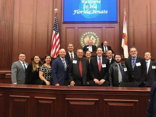 Chiropractic Day in Florida's Senate. Chiropractor Tom Hughes in in the center of the photo with a red tie and dark shirt.