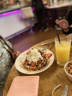 Strawberries, bananas, Nutella, vanilla ice cream piled onto a waffle