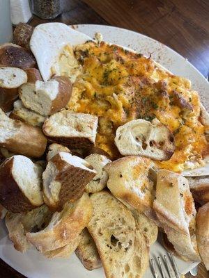 Crab dip with half soft pretzels and toasted baguettes