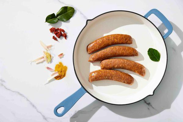 Thai Style SAI UA Sausage: Flavored with red curry paste, lemongrass, lime leaf, turmeric, tamari soy sauce, and other zesty spices.