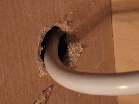 This is the sloppy hole they drilled in a brand new kitchen cabinet.  They didn't even bother to try to clean it up or clean up the sawdust.