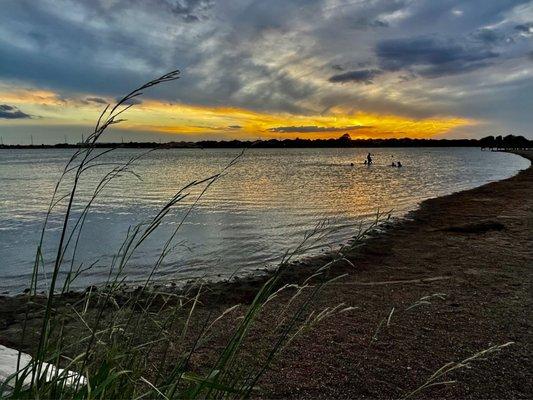 People entering the water and sunset.