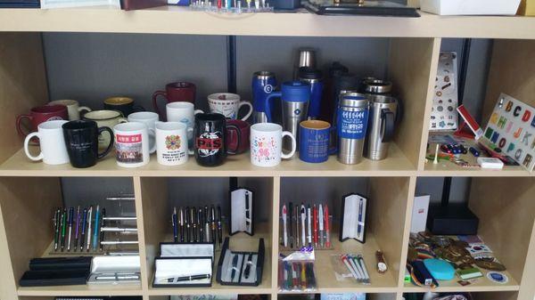 Custom mugs, tumblers, pens, pencils, and more promotional products.