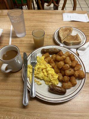 Cafe special with scrambled eggs, links, tater tots, coffee and a shot of grapefruit juice.