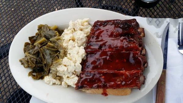 Barbecue pork spare ribs potato salad and fresh collard greens