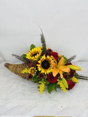 This autumn table floral arrangement is designed with sunflowers,orange lilies,red roses,salidago and mixed greenery