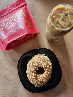 A bag of the seasonal Christmas coffee, almond milk used latte, and a strawberry jam and hazelnut donut.