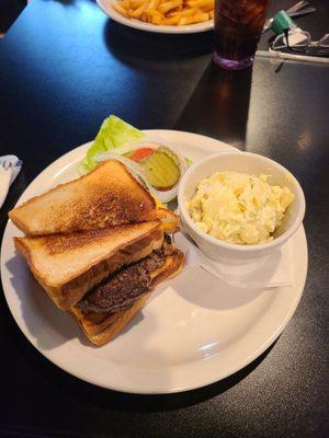 Delicious burger between 2 grilled cheese sandwiches.