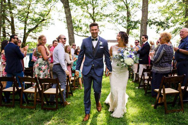 A bride and groom walk down the aisle at their lakeside Maine wedding. Photo by Kate Crabtree Photography.