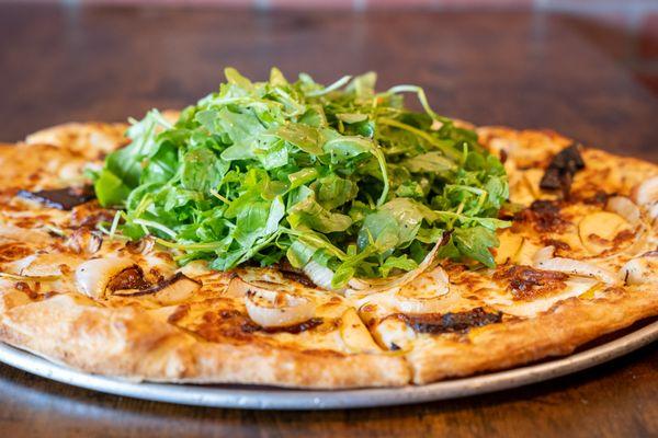 Red Apple Pizza; Hickory Smoked Bacon, Caramelized White Onion, Green Apple & our Creamy Garlic Sauce topped with a fresh Arugula