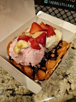 Strawberry and vanilla ice cream with chocolate cream, bananas, strawberries, and waffle