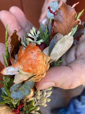 Flowers should be WHITE - Stained orange by the brown leaves used reacting to the water the florist spritzed into the bags.