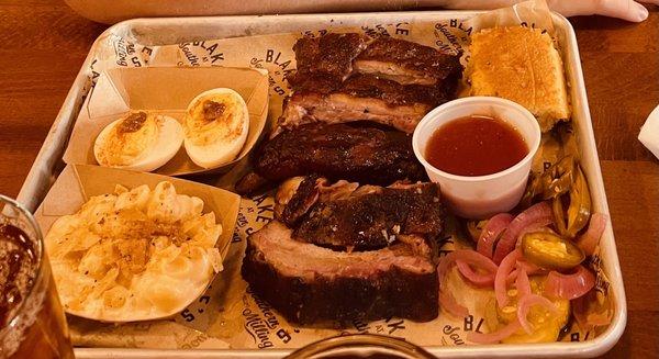 Delicious rib plate! With deviled eggs, and Mac & cheese sides.  Jalapeño cornbread and homemade pickles as accompaniments.