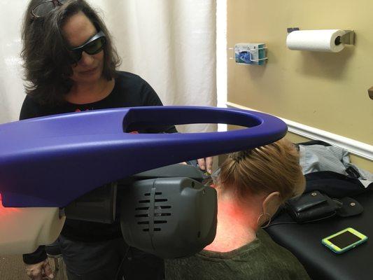 Margy using the MLS robotic laser on a patient with neck pain.