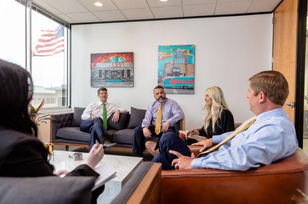 Graham Sutliff, Hank Stout, and Kelly Walne, attorneys at Sutliff & Stout, discuss case details with staff.