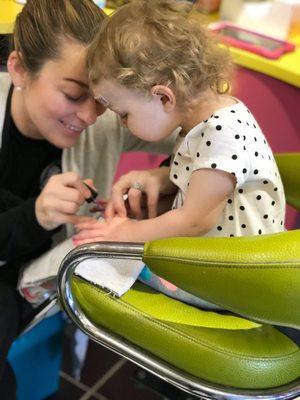 My daughter receiving her first manicure