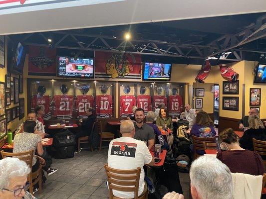 Back wall with authentic autographed jerseys and helmets