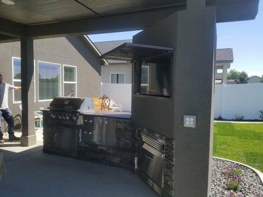 Outdoor Kitchen complete with a fireplace and TV