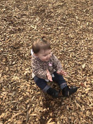 Playing on the playground. She loves the bark.