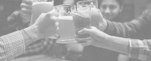 Group of people clinking their beer glasses together in a celebratory toast at SLU BRU.