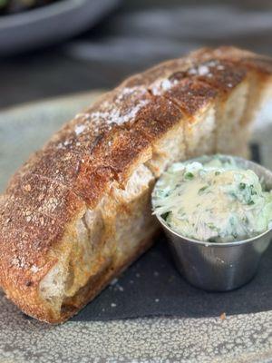 Warm fresh bread with creamy herb butter