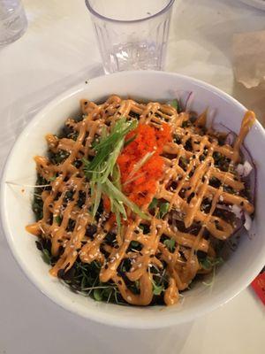 Poke bowl with sushi rice, salmon, furikake, shoyu sauce, spicy mayo sauce, and a few mixed vegetables.