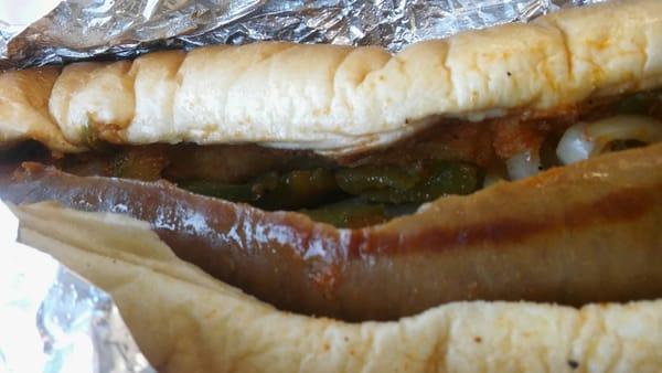 Beef Italian sausage sandwich with green bell peppers, onion, hot sauce