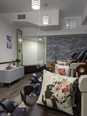 Pedicure stations, set up with Plexi barriers and throw pillows