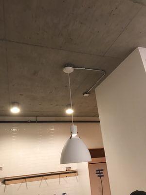 Exposed conduit installation on a concrete ceiling to move a light fixture to a desired location.