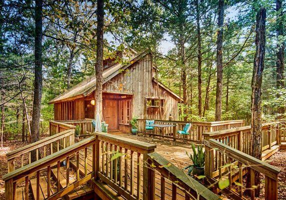 Cabin set at bottom of hill in woods. Front & back porch & decks include swings, hammocks, tonka trucks, tables & chairs.  Pets welcome.