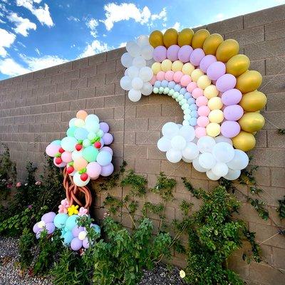 Behold a stunning garland of balloons and a magnificent tree in the backyard, transforming any event into a magical spectacle.