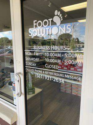 Front door of store with hours open.