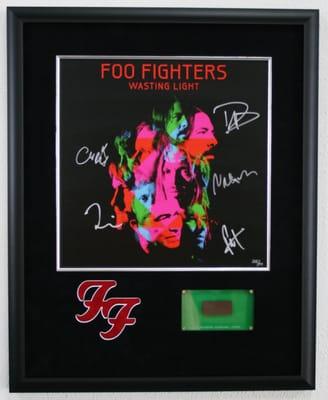 Foo Fighters signed photo with logo cut into mat and section of master recording.