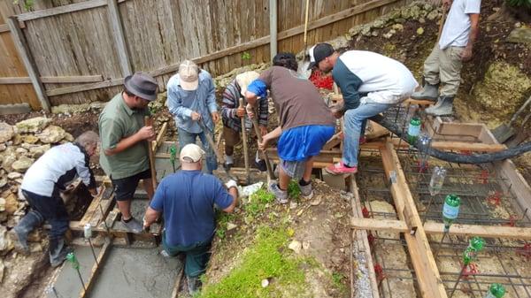 Crew working concrete into my footing forms.  Finishers following with floats.