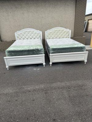 2 white identical full size bed frame with brand new full size plush mattresses and box springs in plastic