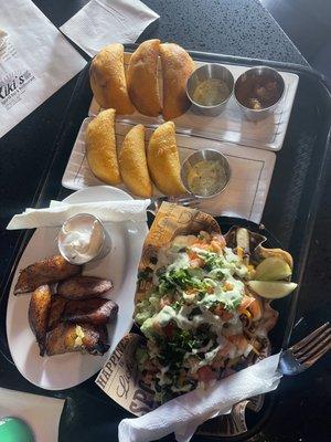 Side of fried plantains, beef and chicken empanadas that come with delicious sauces, and asada fries