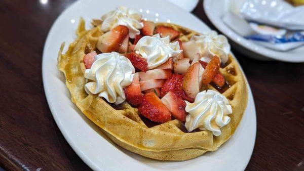 Waffle topped with strawberries and whipped cream! Yummy