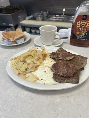 Sausage patties scrapple eggs potatoes and toast.