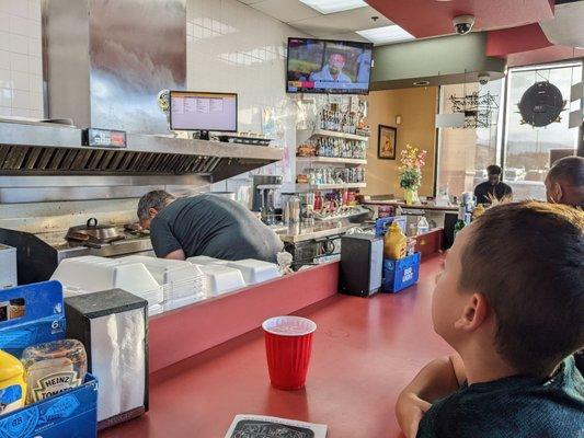 Sit at the counter and watch sports, and see them cook in action