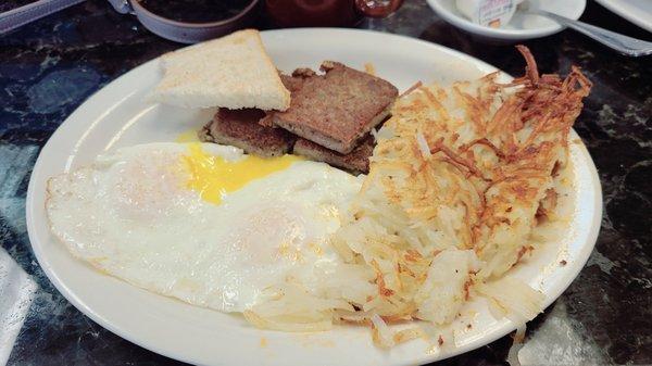 Eggs over easy, scrapple, hash browns, and a bit of toast.